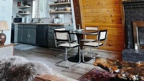 Ein gemütliches Blockhaus-Interieur mit Essbereich, Küche und Kamin.