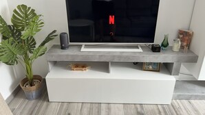 A modern living room with a flat-screen TV, a large plant, and a minimalist entertainment unit. - Schön, Modern und Ruhige Lage. Nah am Zentrum Perfekt für 4. Parking, Netflix (Arona)