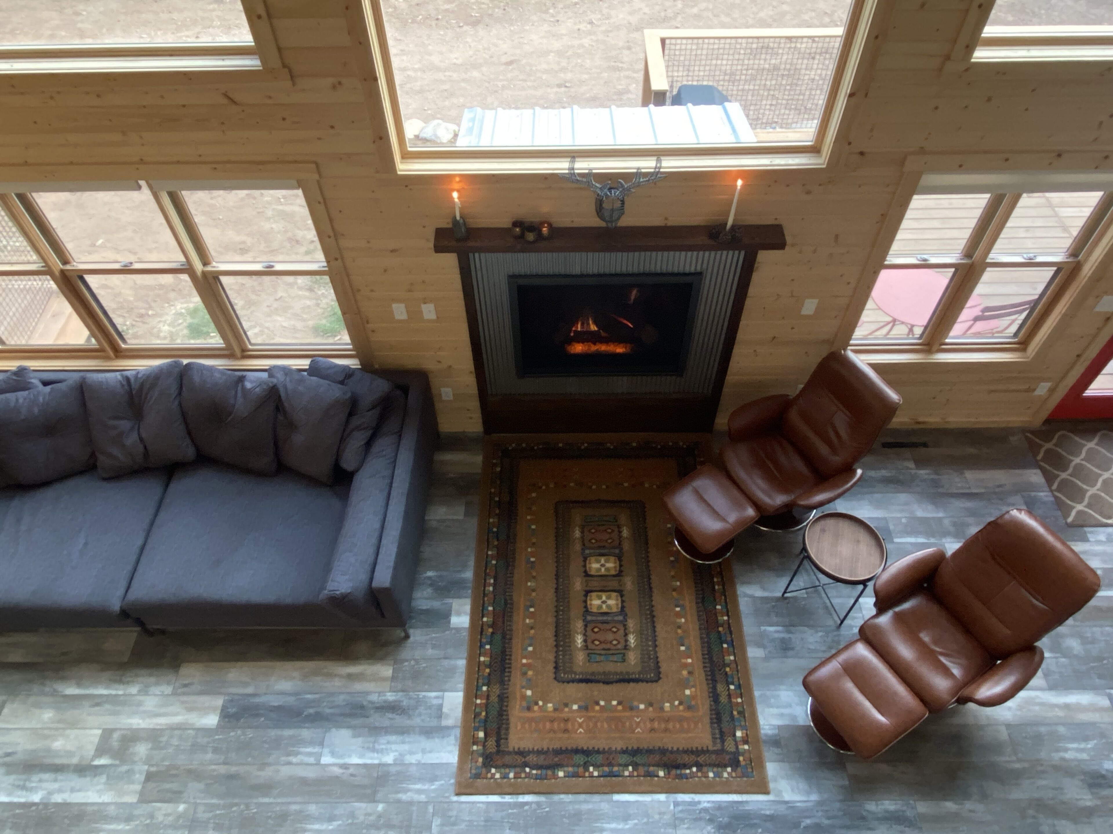 Una sala de estar acogedora con chimenea, sillones de cuero y un sofá de color oscuro.