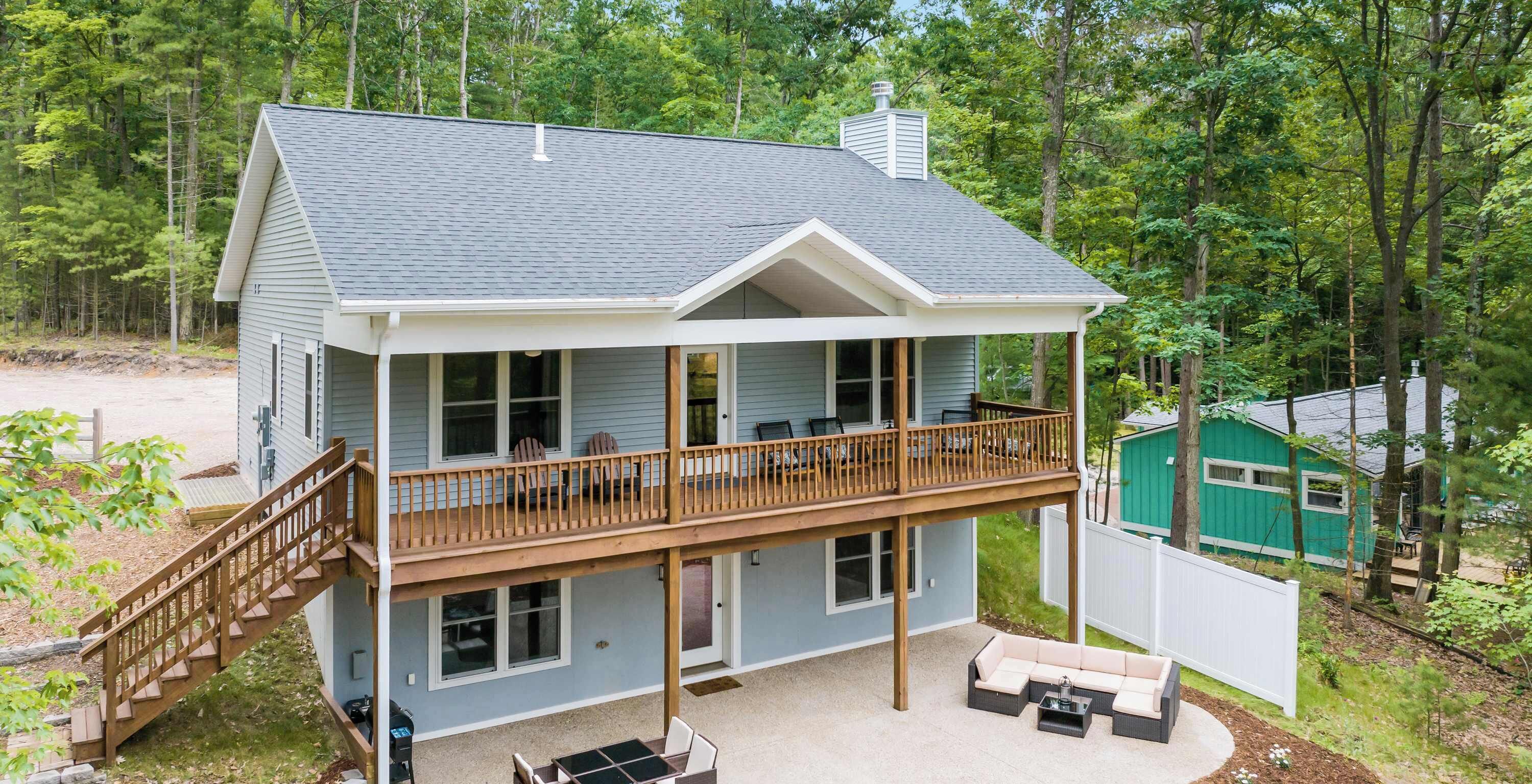 Een huis met twee verdiepingen, een balkon, een terras en een patio.