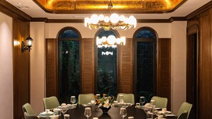 A dining room with a round table set for six, surrounded by green upholstered chairs. - Holiday Inn Express Shanghai Hongqiao Linkong by IHG (Shanghai)