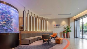 A modern reception area with a large aquarium, seating, and a slogan on the wall. - Holiday Inn Express Shanghai Hongqiao Linkong by IHG (Shanghai)