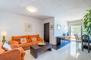 A living room with a sofa, coffee table, and dining area with chairs. - Apartment "La Mar" with Private Terrace & Wi-Fi (Altea)