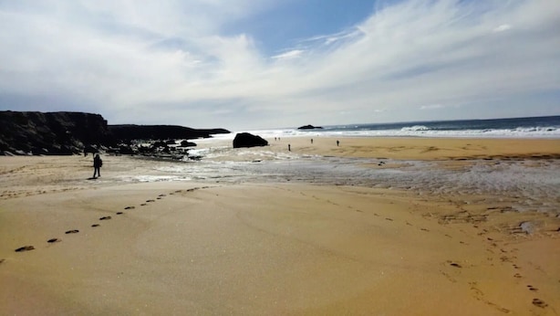 A beach with footprints leading to the water, a rocky cliff, and a clear sky. - Studio Apartment 'Au Coeur De Quiberon' with Shared Pool, Balcony and Wi-Fi (Quiberon)
