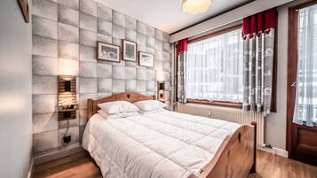 2 dormitorios y tabla de planchar con plancha