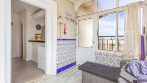 A compact living space with a kitchenette, a dining area, and a window with a view.