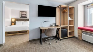 A hotel room with a bed, desk, chair, TV, wardrobe, and a heater. - Best Western Buffalo Inn & Suites (Buffalo)