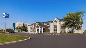 A modern hotel with a prominent sign, a parking lot, and a well-maintained lawn. - Best Western Buffalo Inn & Suites (Buffalo)