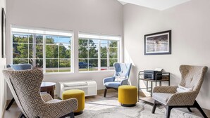 A modern living room with large windows, a fireplace, and a comfortable seating area. - Best Western Buffalo Inn & Suites (Buffalo)