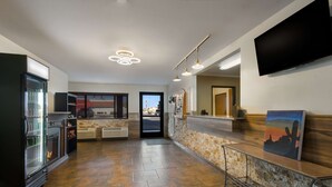 A modern kitchen with a stone countertop, a built-in refrigerator, and a flat-screen TV mounted on the wall. - SureStay by Best Western Camp Verde (Camp Verde)