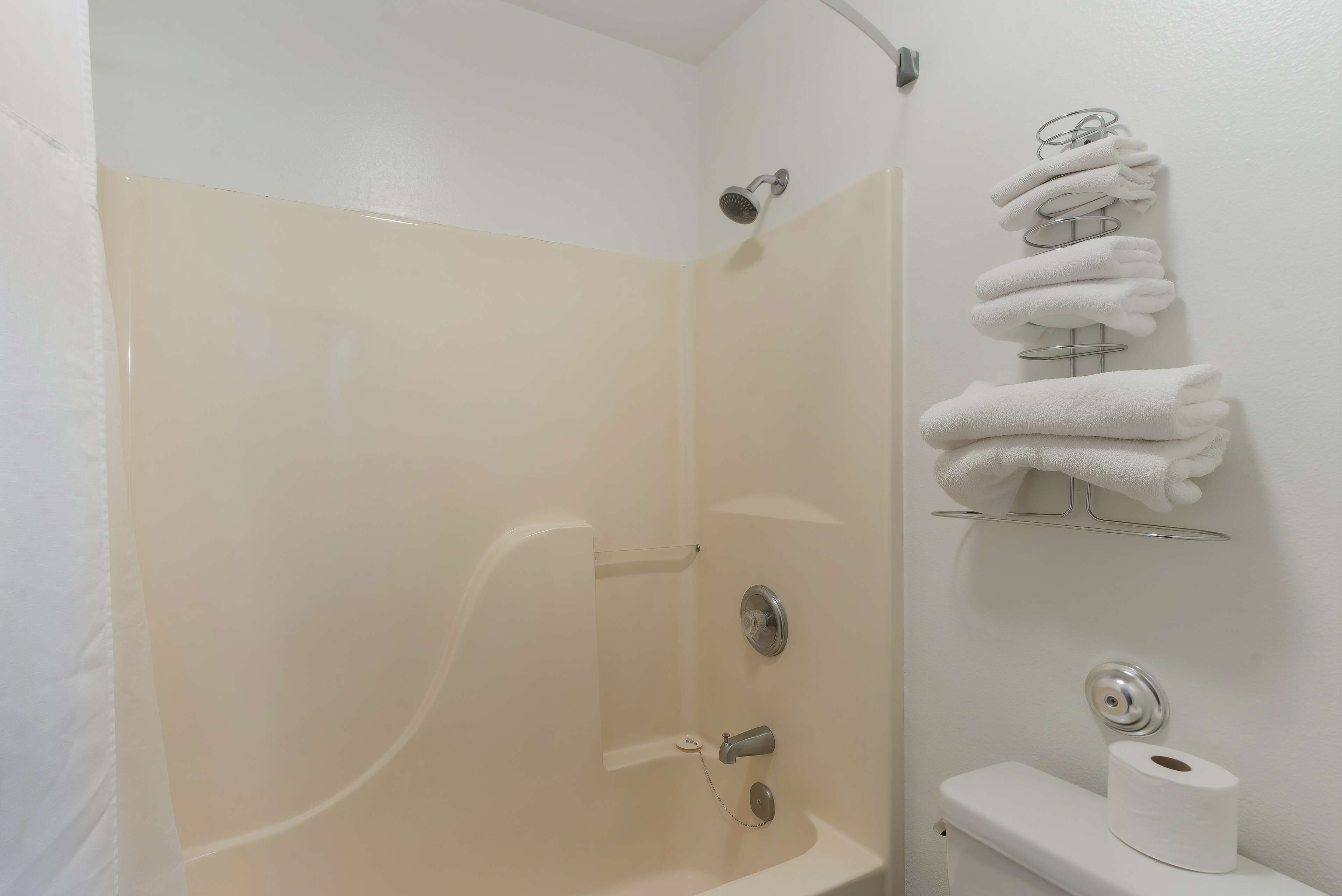 Een badkamer met douche, toilet en handdoekrek.