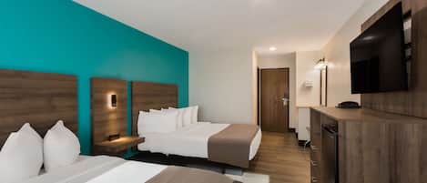 Quarto de hotel com duas camas, televisão, mesa de trabalho e banheiro.