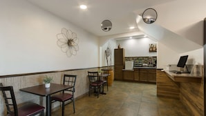 A restaurant with a dining area featuring a table and chairs, a kitchen in the background, and a decorative wall piece. - SureStay by Best Western Camp Verde (Camp Verde)