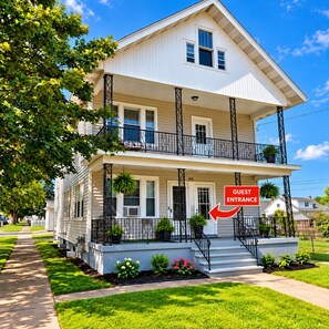 A two-story house with a guest entrance, a balcony, and a well-maintained lawn. - Spacious Hidden Gem (Utica)