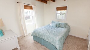 A bedroom with a bed, a nightstand, a window with curtains, and a ceiling fan. - Endless Summer - Resort Area - Vibe District VB (Virginia Beach)
