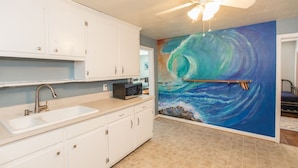 A kitchen with white cabinets, a sink, a microwave, and a ceiling fan. - Endless Summer - Resort Area - Vibe District VB (Virginia Beach)