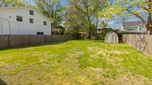 A backyard with a wooden fence, a shed, and a house. - Endless Summer - Resort Area - Vibe District VB (Virginia Beach)