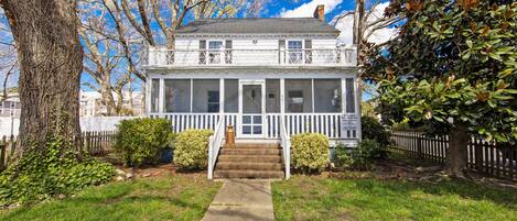 A two-story house with a front porch, a covered entryway, and a small front yard.