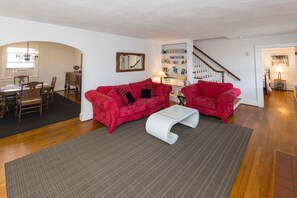 A living room with a red sofa, a white coffee table, and a bookshelf.