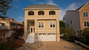 A two-story house with a garage, a front porch, and a landscaped yard. - A Wave From It All - Croatan VB (Virginia Beach)
