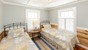 Ein Zimmer mit zwei Betten, einem kleinen Tisch mit Lampe und einer Dekoration mit Seestern.