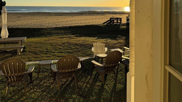 Een veranda met buitenmeubilair met uitzicht op een strand.