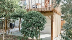 A wooden deck with a railing, surrounded by trees and shrubs. - North End Paradise - North End VB (Virginia Beach)