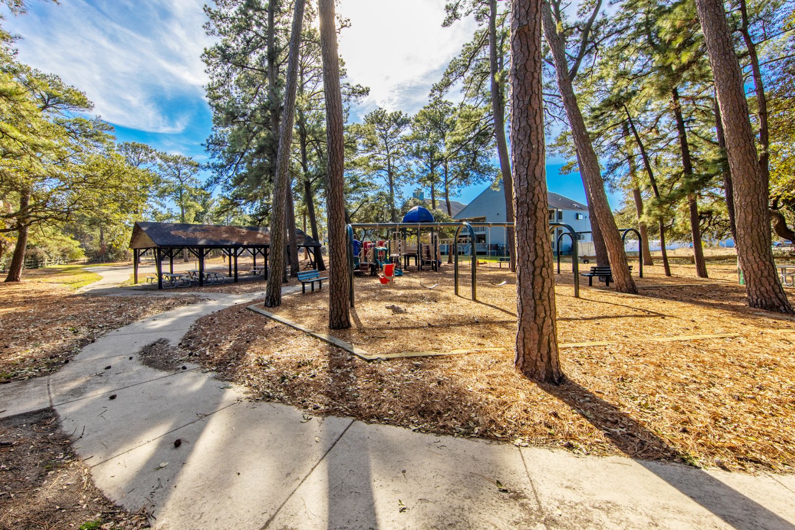A park with a playground, picnic tables, and a covered pavilion.