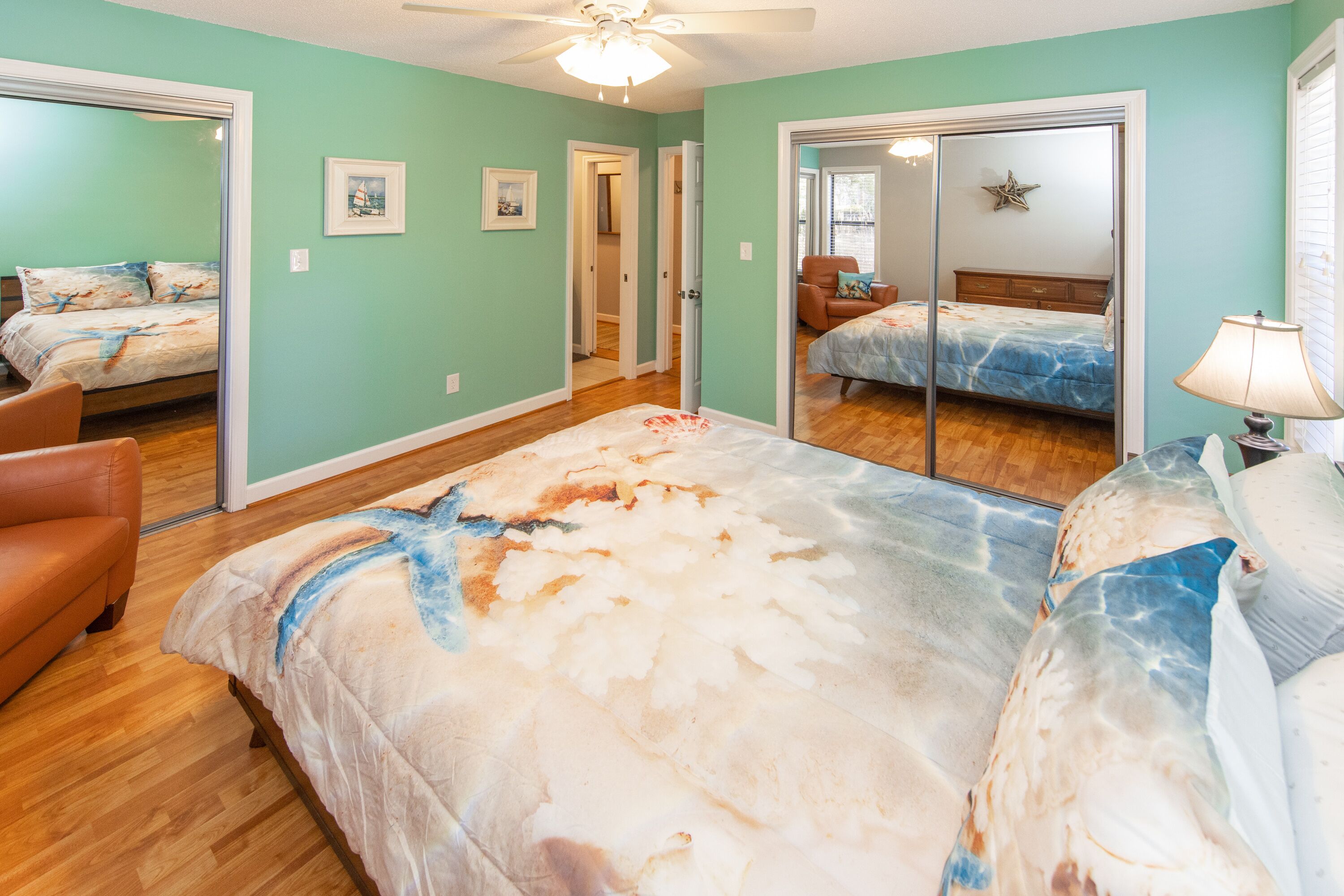 Une chambre à coucher avec un grand lit, une chaise et un ventilateur de plafond.