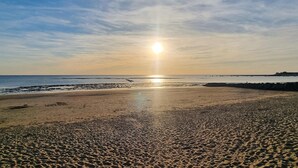 A beach with the sun low on the horizon, casting a warm glow over the sand and water. - Gorgeous home in Saint-Martin-de-Ré with WiFi (Saint-Martin-de-Ré)