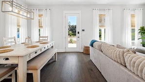 Ein modernes Interieur mit Essbereich, einer Couch und Blick durch eine Tür.