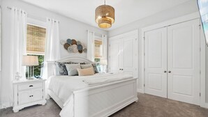 Ein Schlafzimmer mit Bett, Nachttisch, Schminktisch und großem Kleiderschrank.