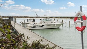 Um barco atracado no cais, com um círculo boiador preso a um poste.