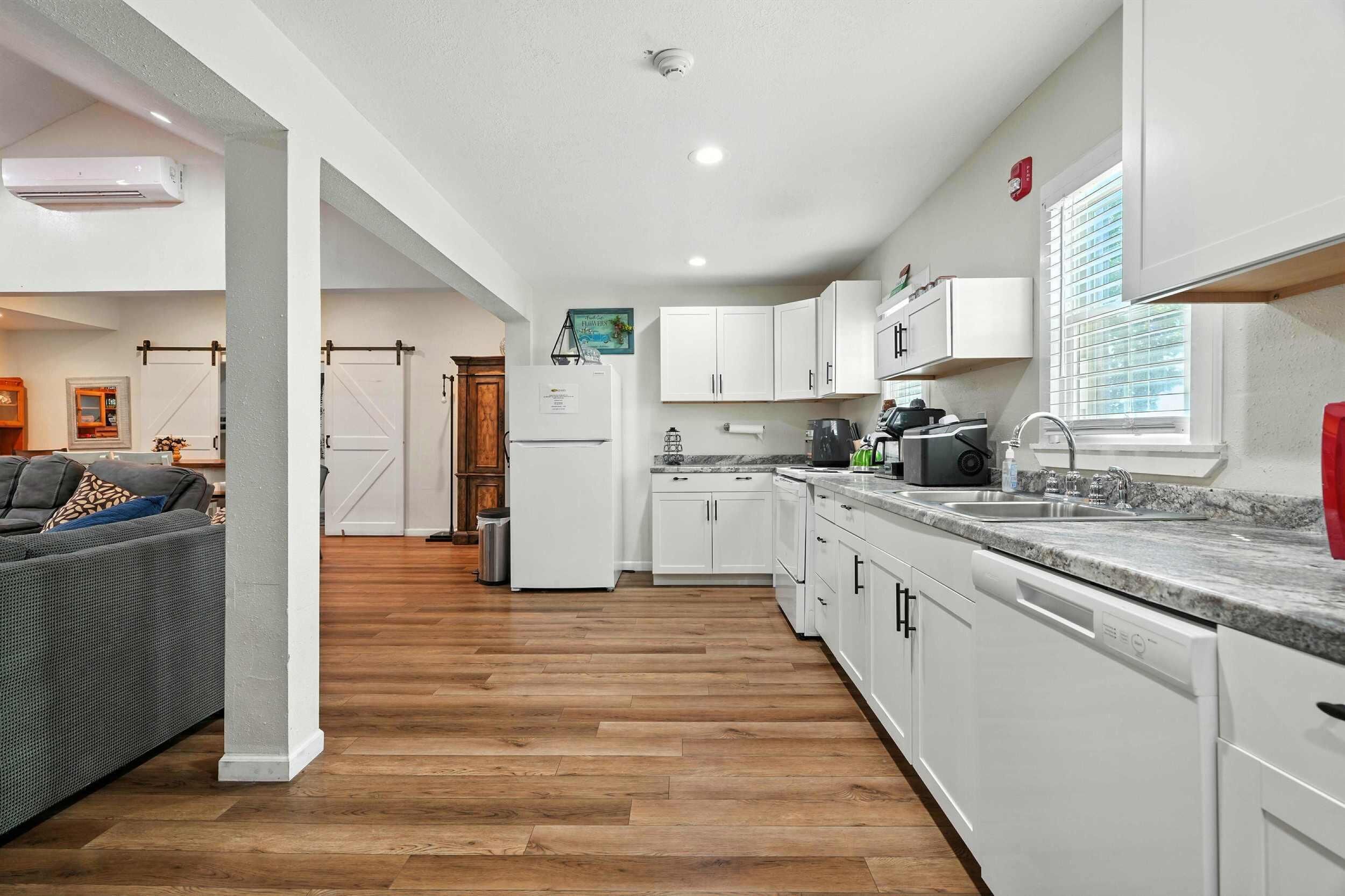 A modern kitchen with white cabinets, a granite countertop, and a built-in oven.