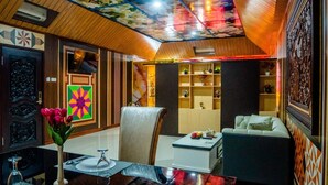 Una sala de estar moderna con un sofá, una mesa de comedor con tulipanes y un televisor.