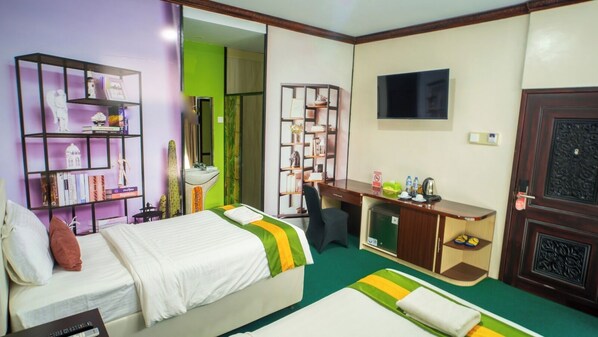Una habitación de hotel con una cama, un escritorio, un televisor y una estantería.