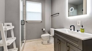 A modern bathroom with a toilet, sink, and shower. - ADU Washer and Dryer Kitchen Walk Bishop Arts (Dallas)