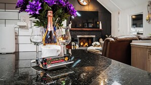 Una encimera de cocina con una botella de champán, dos copas y una caja de galletas.