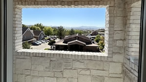 A room with a stone wall and a window overlooking a parking area and buildings. - Stay in the top 2 floors of the brand new Silo Inn, near Zion!  (Washington)