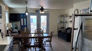 A spacious kitchen with a dining area, wooden cabinets, a refrigerator, and a ceiling fan. - Villa Cape San Blas - Gulf View Townhome, Steps from the Beach & Local Dining (cape san blaste)
