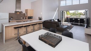 Una cucina moderna con isola centrale, sgabelli da bar e tavolo da pranzo.