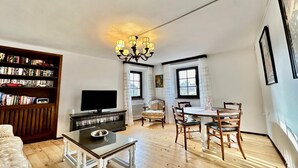 A living room with a TV, bookshelf, dining table, and chairs. - Casa Matilde 2 in Gerra Gambarogno, Gambarogno, Gerra, Switzerland (Gambarogno, Gerra)