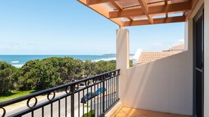 A balcony with a view of the ocean, a car parked outside, and a building with a tiled roof. - Breakers 1/10- Stone Real Estate Yamba (Yamba)