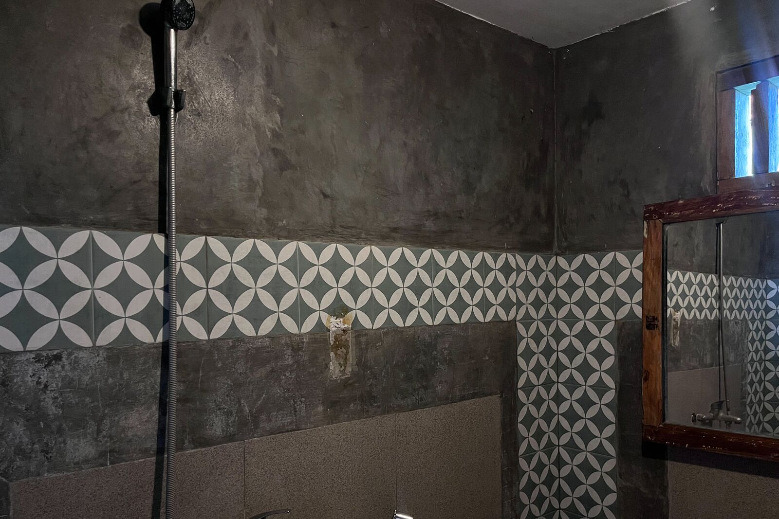 A bathroom with a shower, a towel rack, and a mirror.