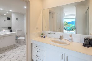 Une salle de bain moderne avec un lavabo, des toilettes et un meuble-lavabo blancs.