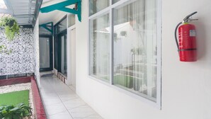Esterno di un edificio con ampie finestre, un estintore montato sulla parete e una tettoia.