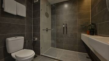 A modern bathroom with a toilet, shower, and sink.