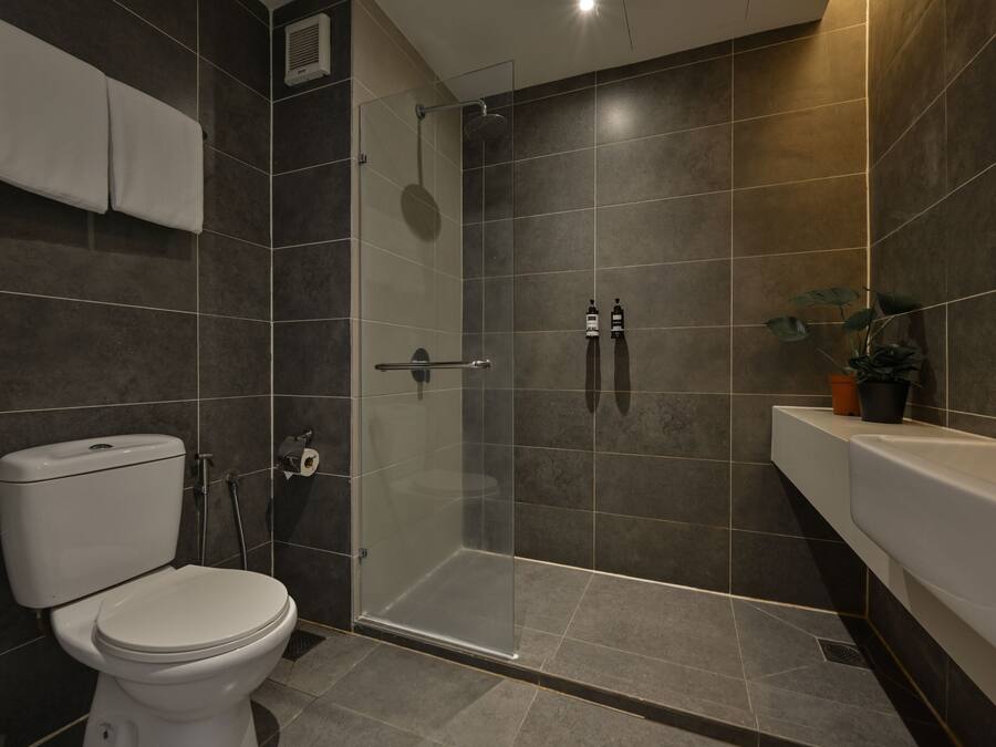 A modern bathroom with a toilet, shower, and sink.
