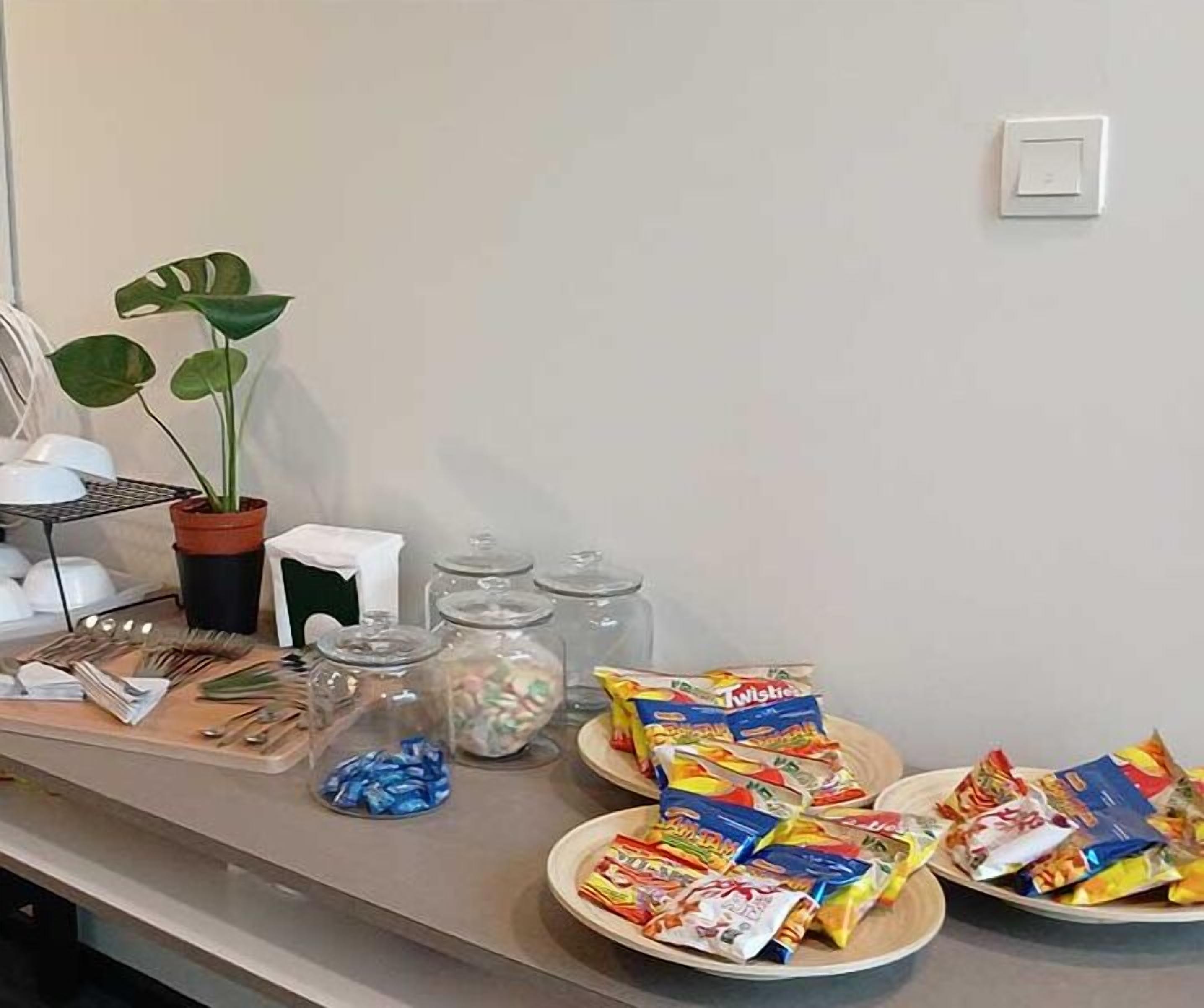 A buffet table with various food items, including Twinkies, and a potted plant.