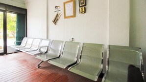 Een wachtruimte met metalen stoelen, een wandklok, ingelijste certificaten en een bordje met 'DTA'.